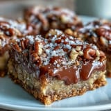 Decadent turtle bars feature a buttery crust loaded with oats, chocolate chips, and caramel sauce.