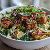 Golden pan-fried tofu cubes tossed with crisp cabbage, carrots, and spinach in a savory umami sauce for a Tofu Egg Roll in a Bowl