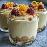 Elegant lemon mousse in individual cups, served with golden shortbread cookies for a refreshing dessert.  