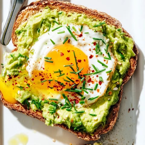 Fluffy avocado toast topped with fresh cilantro and chili flakes, quickly made.