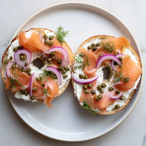 Golden-brown bagel halves generously slathered with creamy spread and fresh veggies for a quick breakfast.