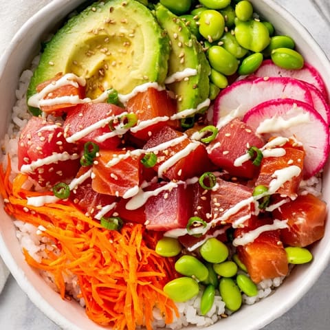 Crisp cucumber, julienned carrots, creamy avocado, and edamame add fresh texture to a vibrant, healthy Poke Bowl.