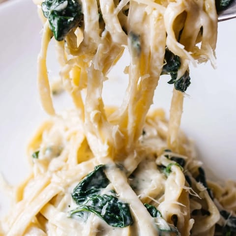 A close-up of Creamy Garlic Spinach Pasta garnished with parsley and extra Parmesan, ready to serve for a comforting weeknight dinner.  