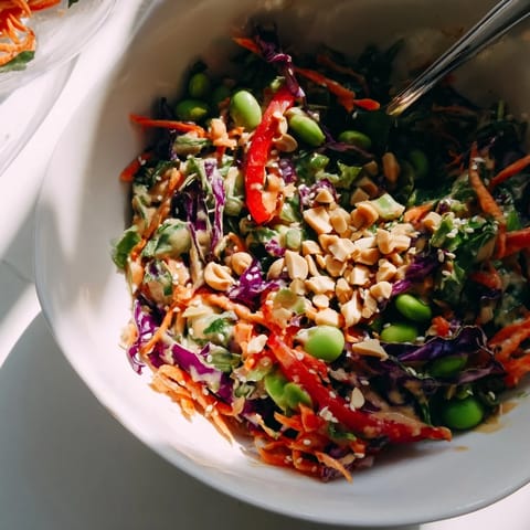 Crunchy Thai Peanut Salad with vibrant shredded carrots, cabbage, and edamame in a creamy, tangy peanut dressing.  