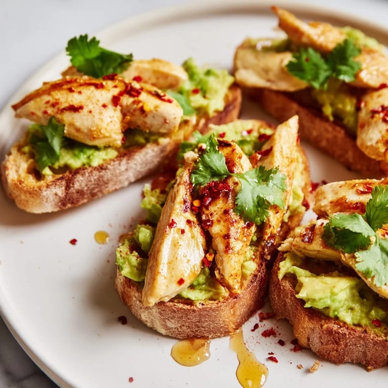 Golden multigrain toast holds seasoned grilled chicken and luscious smashed avocado, with honey and chili flakes adding a savory-sweet kick for a quick, satisfying meal.