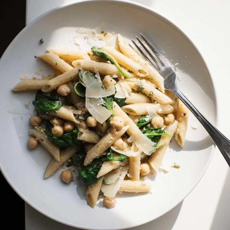 Close-up of Creamy Tuscan Chickpea Pasta with tender chickpeas and garlic-infused creamy tomato sauce, ready to be enjoyed warm.
